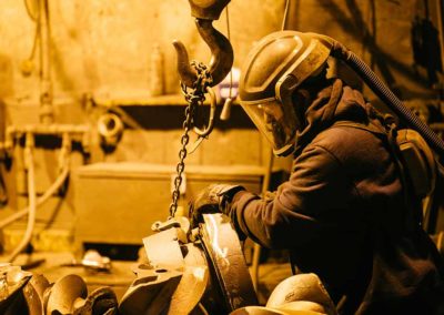 A foundry worker prepares a cast iron component for finishing processes at Taylor & Fenn.
